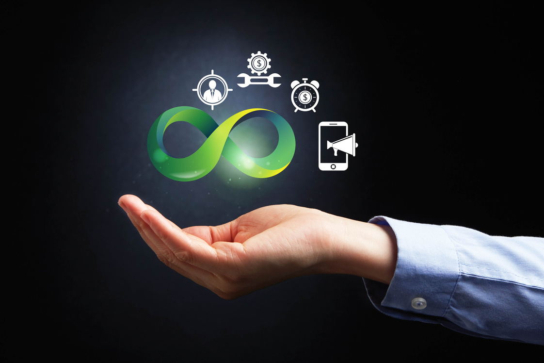 Cupped hand presenting an infinity logo design with various mobile elements